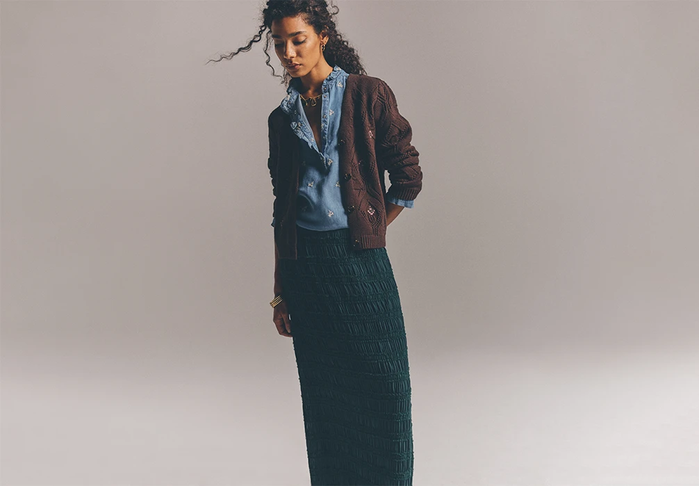 Model is wearing a denim short with a brown knitted cardigan