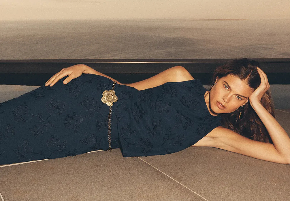 Model lying down wearing the Embroidered Floral Linen Blend co-ord set by an infinity pool