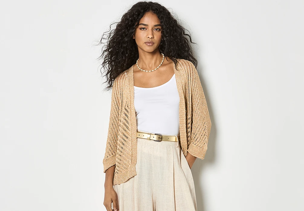 Studio shot of a model wearing the Gold Shimmer Open Knit Cardigan