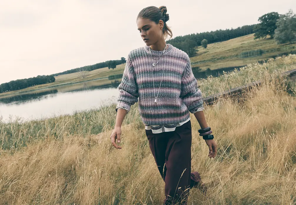 Model is wearing a pink striped knitted jumper
