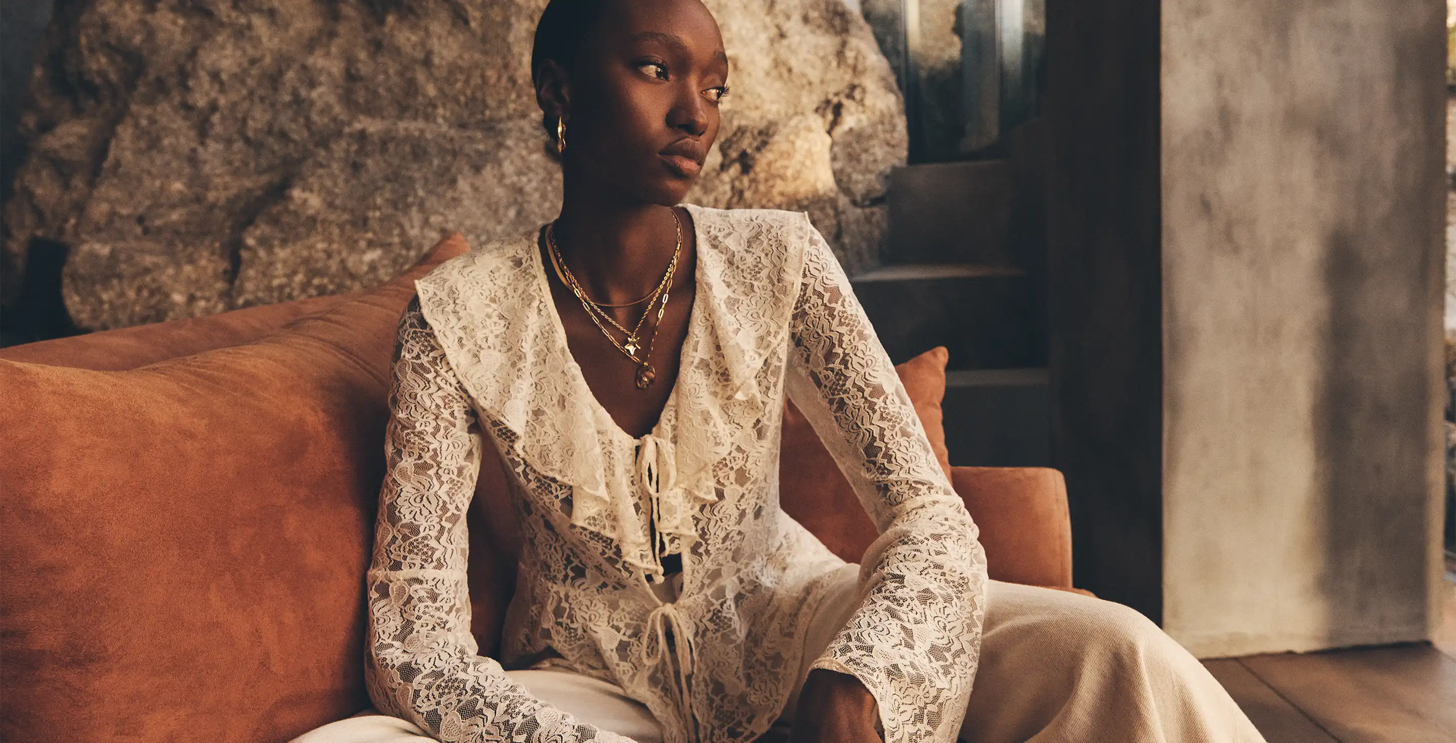 Model sittin wearing the Lace Ruffle Cardigan 
