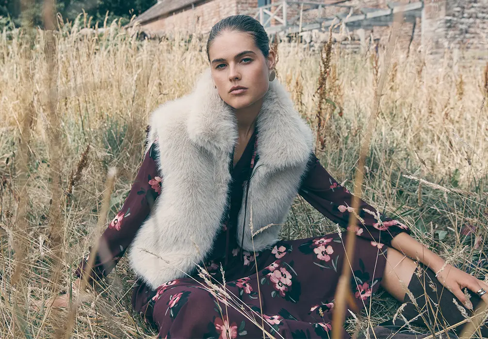 Model is wearing a brown floral print plum dress