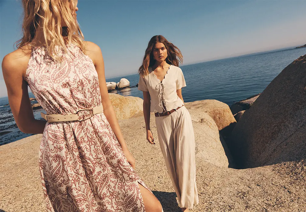 2 models by the sea with 1 model wearing the Paisley Print Satin Maxi Dress