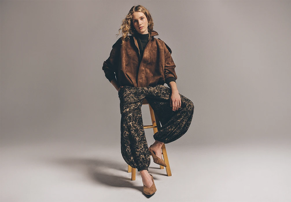 Model wearing leopard trousers and tan suede jacket