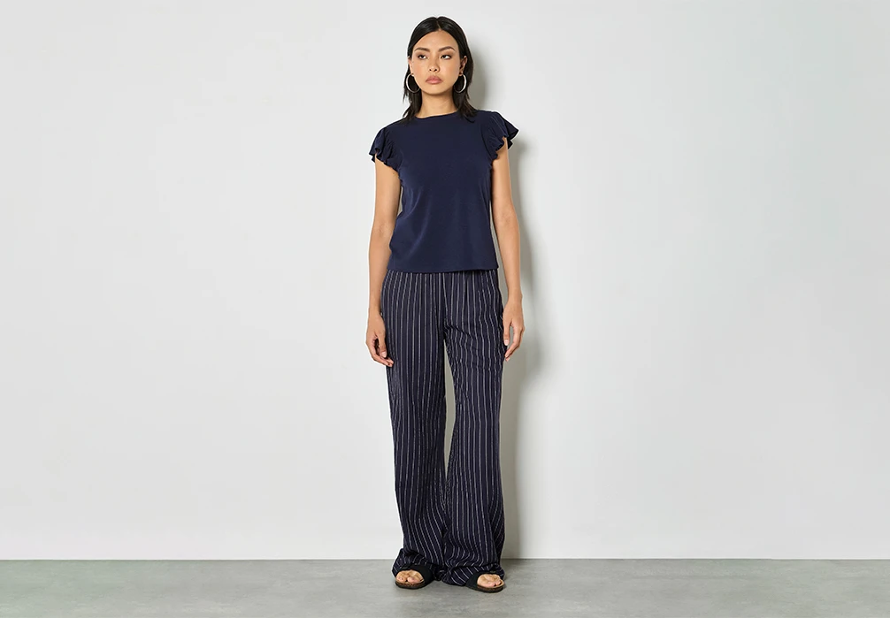Studio shot of model wearing Pinstripe Linen Blend Wide-Leg Trousers