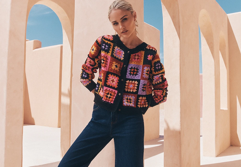 A girl standing in cotton crochet top. Text on image: Tap into this season's crochet trend with colourful tops, dresses and accessories.