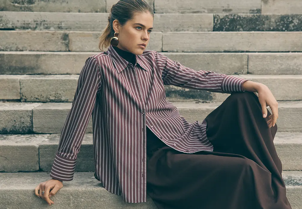 Model is wearing a burgundy stripe shirt