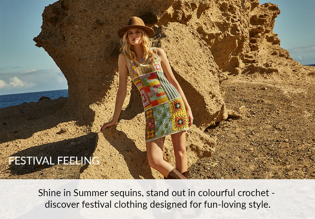 A girl standing in summer dress and hat on the beach. Text on image: Shine in Summer sequins,  stand out in colourful crochet - discover festival clothing designed for fun-loving style.